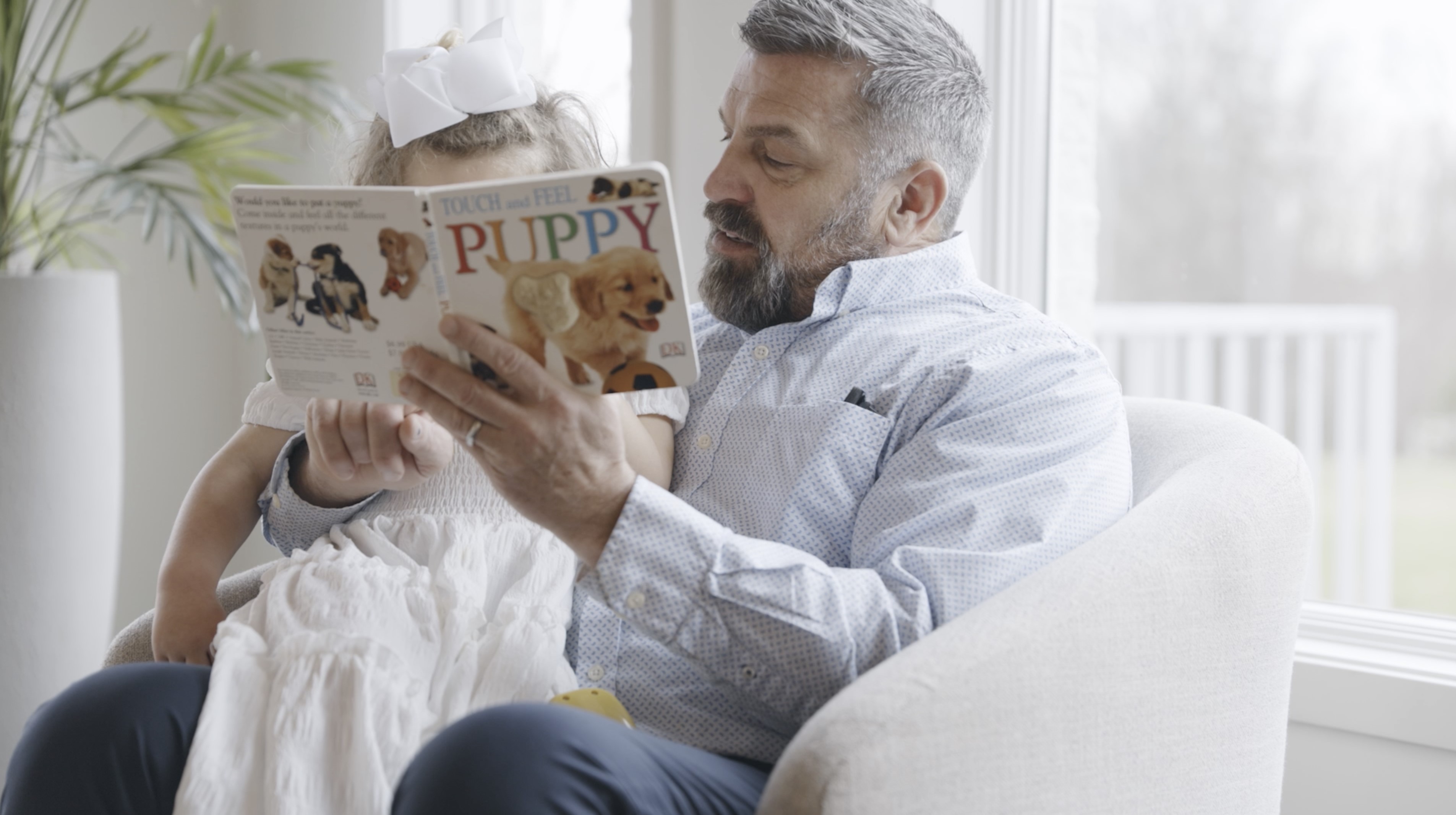 A foster dad reads to a young girl